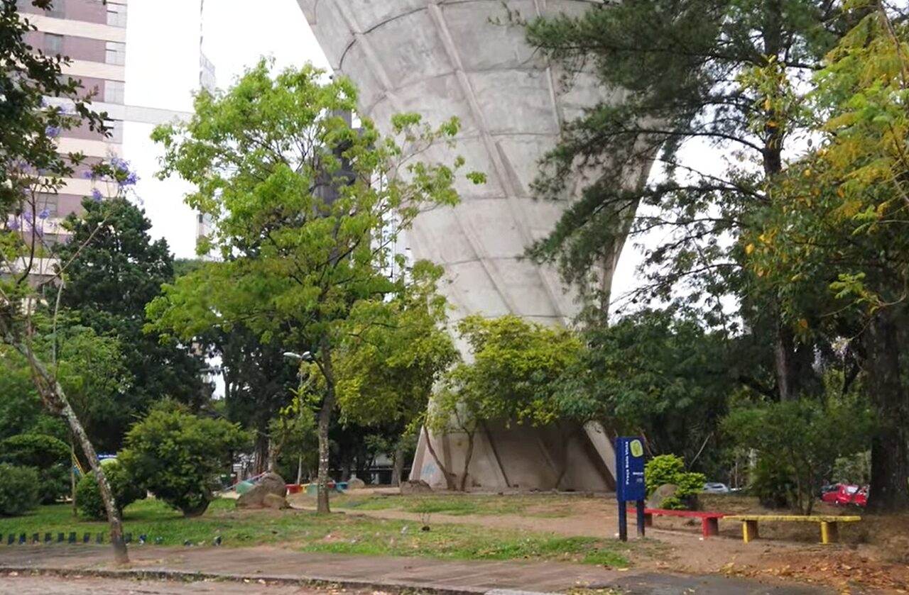 Antiga caixa d’água da Praça Bela Vista, em Porto Alegre, cercada por árvores e vegetação, um dos marcos históricos que deram origem ao nome popular da Praça da Caixa d’Água.