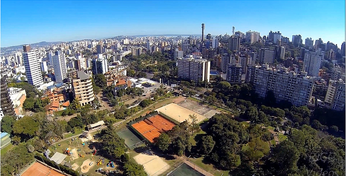 Fachada de arquitetura moderna do Grêmio Náutico União visto de baixo, destacando as varandas geométricas brancas e marrons sob o céu do pôr do sol em Porto Alegre.