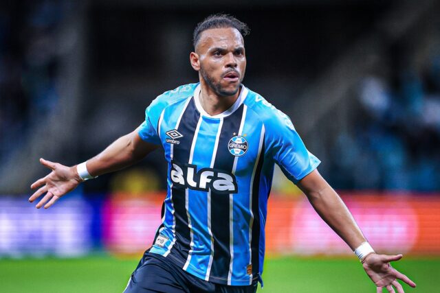 Martin Braithwaite comemorando em campo com a camisa do Grêmio, durante uma partida de futebol. - Martin Braithwaite: Do Futebol ao Império Imobiliário Bilionário